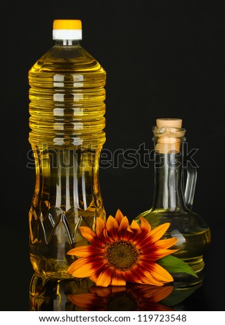 sunflower oil in a plastic bottle and small decanter isolated on black background