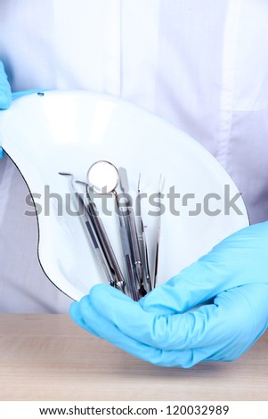 Sterilization tray with dental tools in dentists hands