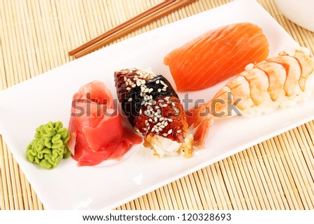 delicious sushi served on plate on bamboo mat