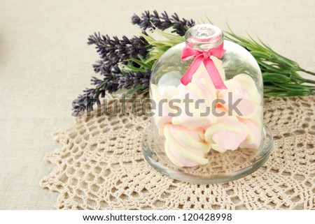 Marshmallows on saucer with transparent cover on light background