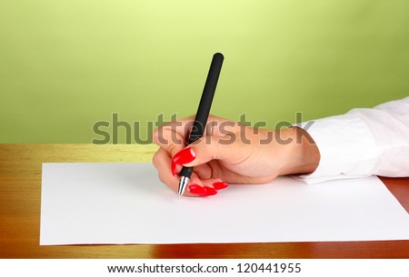 Hands writing on  paper on green background