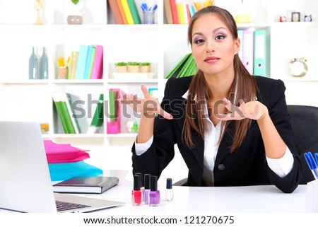 business woman painting nails on work place