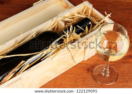 Wooden case with wine bottle on table
