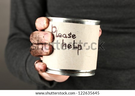 homeless man asks for help, on black background close-up