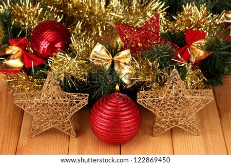 Christmas composition  with candles and decorations in red and gold colors on wooden background