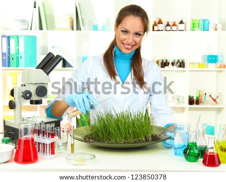 Young female scientist is conducting experiments with plants in  laboratory