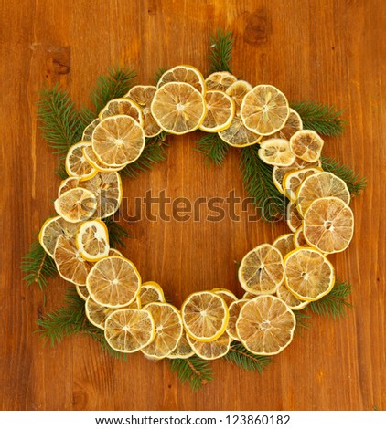 christmas wreath of dried lemons with fir tree, on wooden background
