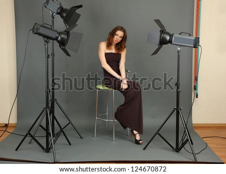 beautiful professional female model resting between shots in photography studio shoot set-up