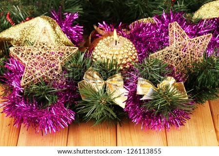 Christmas composition  with candles and decorations in purple and gold colors on wooden background