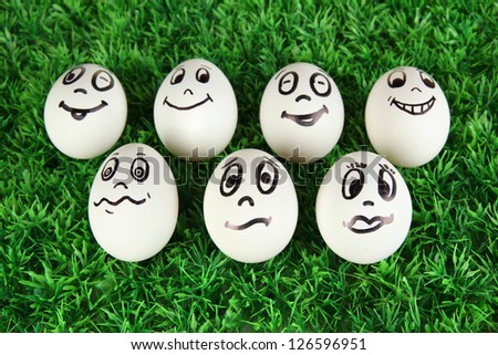 Eggs with funny faces on grass