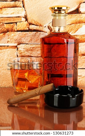 Bottle and Glass of whiskey and cigar on brick wall background