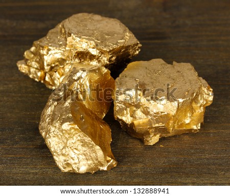 Golden nuggets on wooden background
