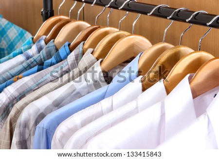 Men\'s shirts on hangers in wardrobe