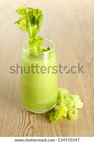 Glass of celery juice on wooden background