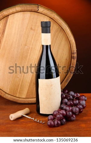 Composition of corkscrew and bottle of wine, grape, wooden barrel  on wooden table on dark background