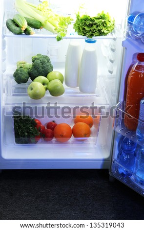 Woman\'s hand reaching out for food from the refrigerator, close up
