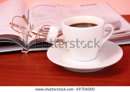 Cup of coffee, book, clock and calculator on wooden table
