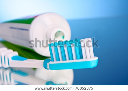 toothpaste and brush on a blue background