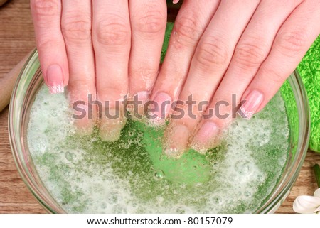 women's hands in the water on wooden background