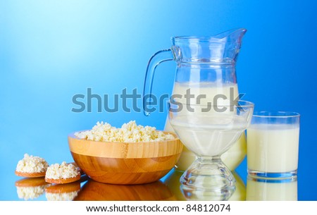 Milk, sour cream and cottage cheese on blue background