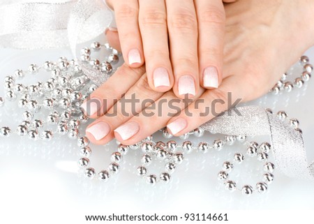 hands with beautiful winter design, ribbon and beads isolated on white