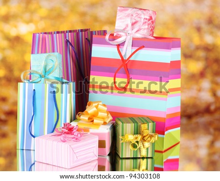 bright gift bags and gifts on yellow background
