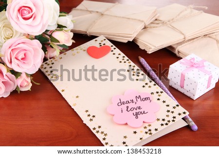 Writing letter of congratulations to mother\'s Day on wooden table close-up