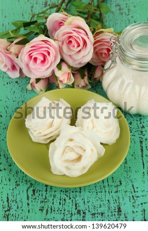 Sugar roses and natural roses, glass jar with sugar,  on color background