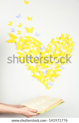 Paper yellow butterfly in form of heart fly out book