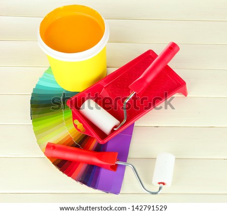 Set for painting: paint pot, paint-roller on white wooden table