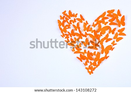Paper butterflies in form of heart on wall