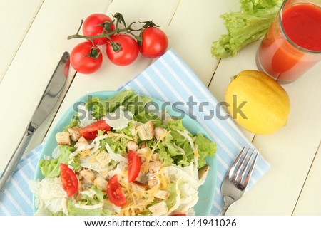 Caesar salad on blue plate, on color wooden background