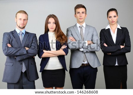 Business team standing in row on grey background