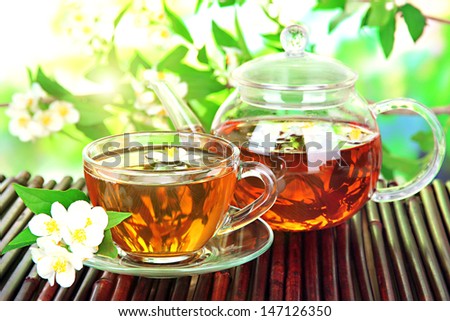 Cup of tea with jasmine, on bamboo mat, close-up