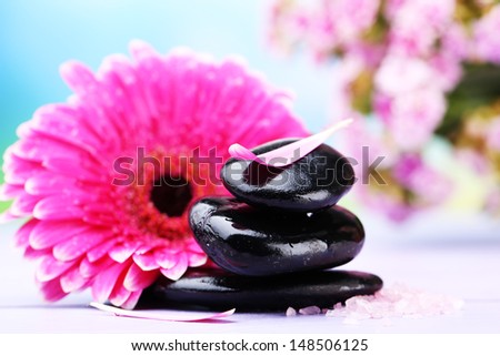 Spa stones and beautiful gerbera on wooden table