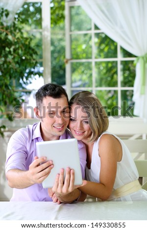 Young couple  taking  photo with tablet in restaurant