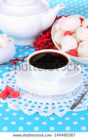Beautiful white dinner service with an air meringues on blue tablecloth close-up