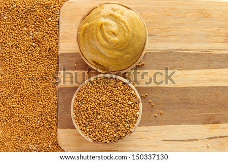 Mustard with seeds on wooden background