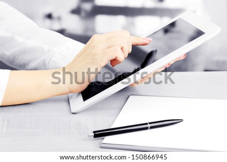 Female office worker using digital tablet in cafe in shades of grey