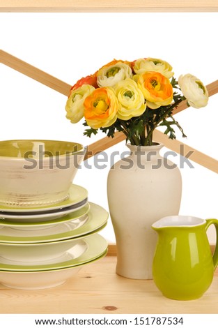 Lots beautiful dishes on wooden cabinet on white background