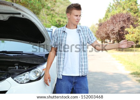 Man on road with car breakdown trying to stop car