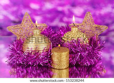 Christmas composition  with candles and decorations in purple and gold colors on bright background