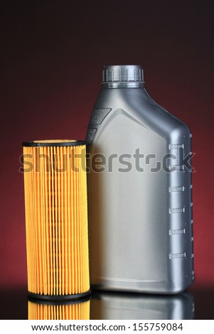 Car oil filter and motor oil can on dark color background