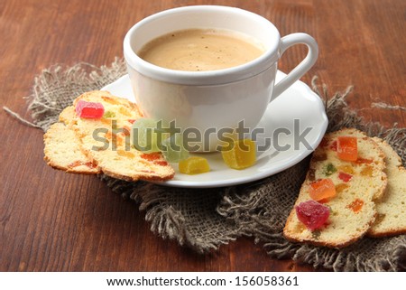 Cup of tasty coffee with Italian biscuit, on wooden background