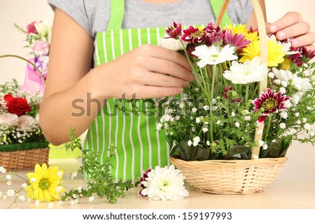 Florist makes flowers bouquet in wicker basket