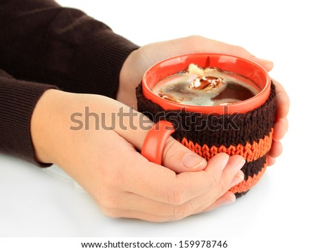 Cup with knitted thing on it in female hands isolated on white