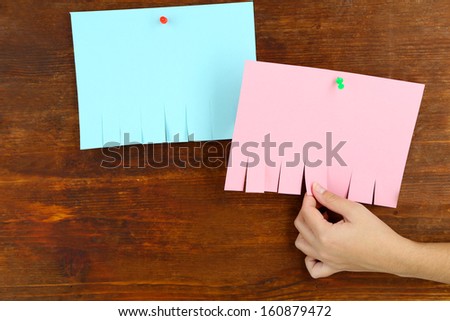 Hand hangs ads on wooden background