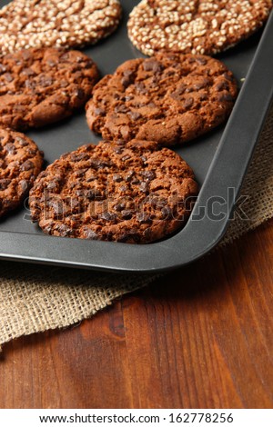 Homemade cookies on dripping pan, on wooden background