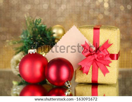Gift boxes with blank label and Christmas decorations on table on bright background