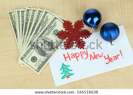 Dollar bills in envelope as gift at New year on wooden table close-up